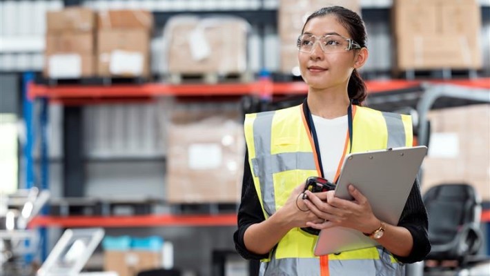 A female employee keeping an eye on the logistics inside the warehouse