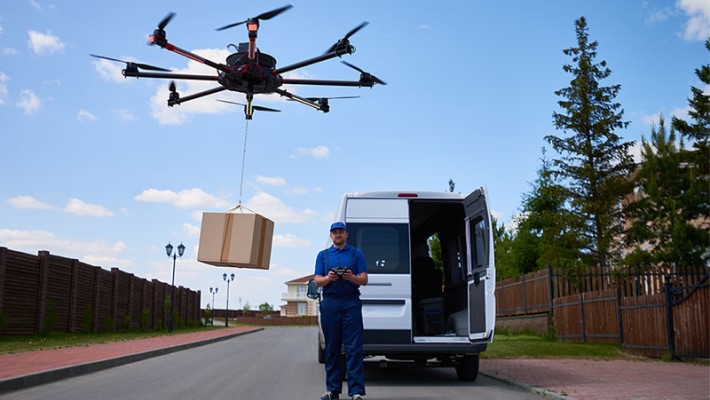 Logistics driver flying a drone to deliver a package