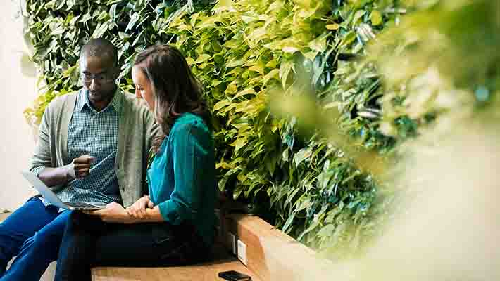 Colleagues sitting on office bench discussing about business strategies