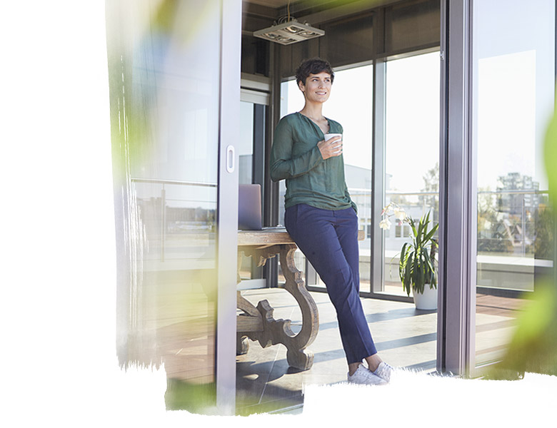 Smiling businesswoman leaning against table having a coffee break