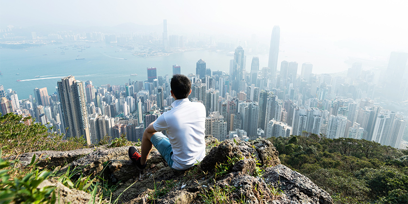 Man sitting and looking at aerial view of Victoria peak Hongkong