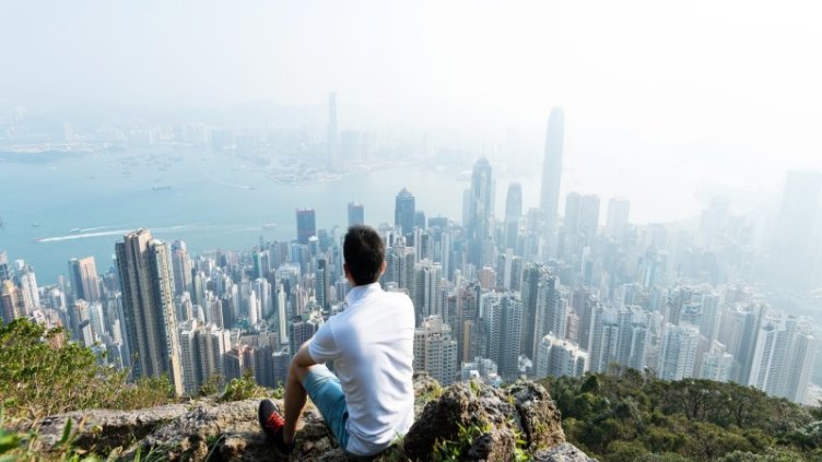 Man sitting and looking at aerial view of Victoria peak Hongkong