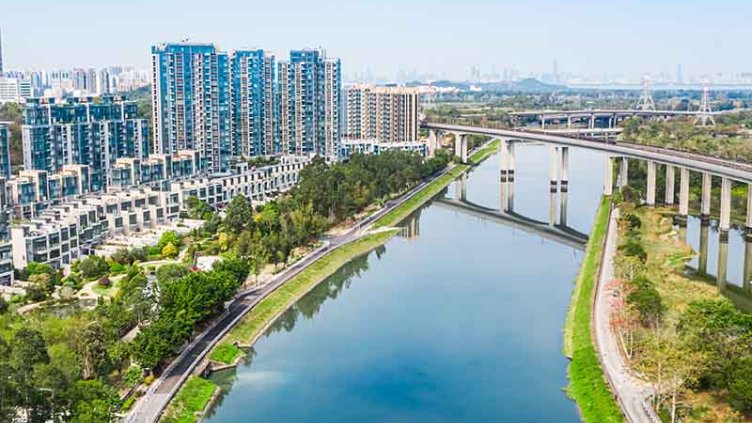 Rail over bridge on river with buildings on background