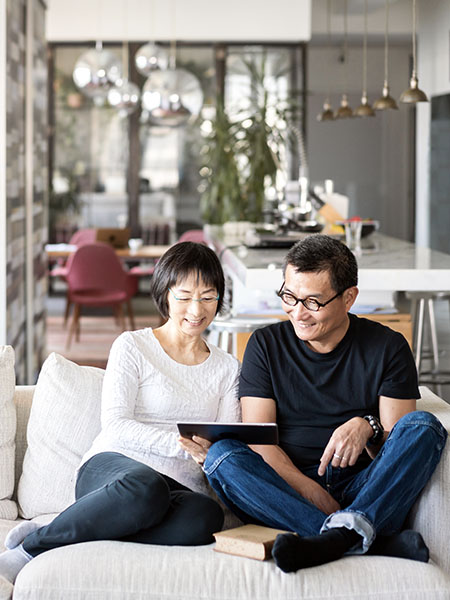 Couples sitting on the sofa and looking on a tab