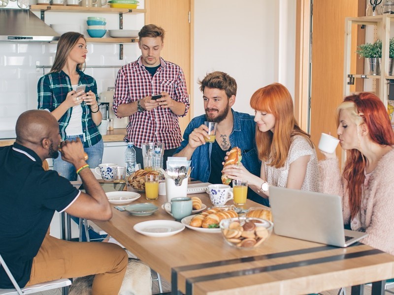 Peoples having breakfast in coliving apartment 