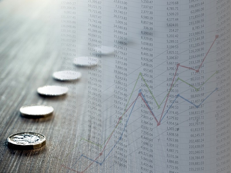 Coins with coloured stock chart and spreadsheet having numbers flowing left to right in flag style