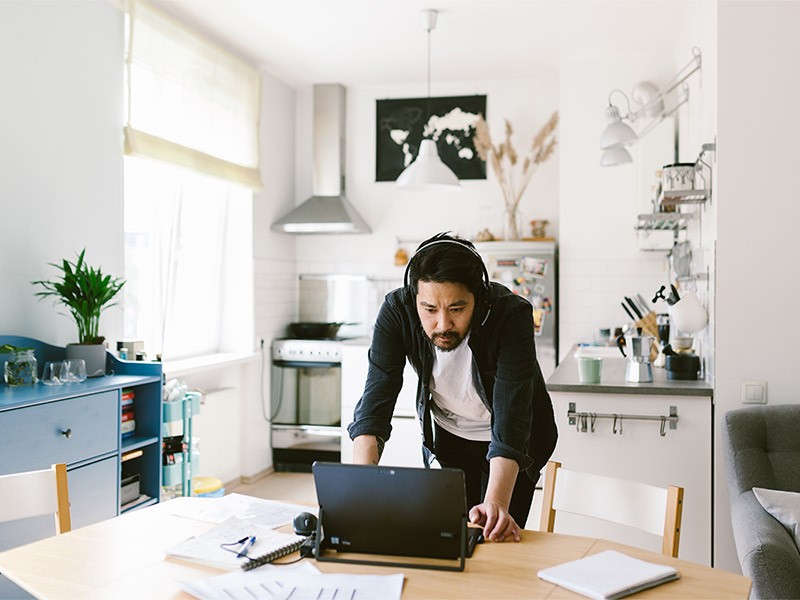 Adult man telecommuting in home office