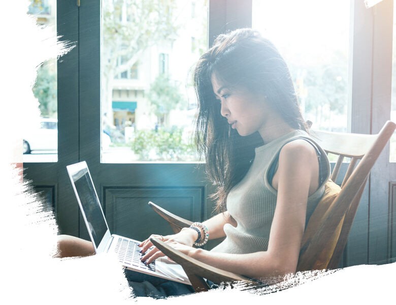 Young woman sitting on the chair and using laptop