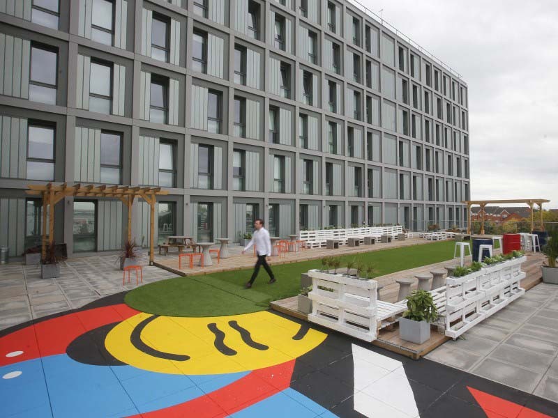 Man passing by the huge building 