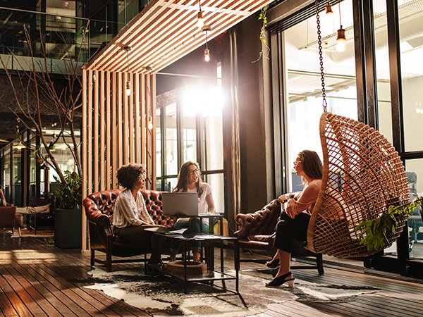 three women conversing in coworking lobby