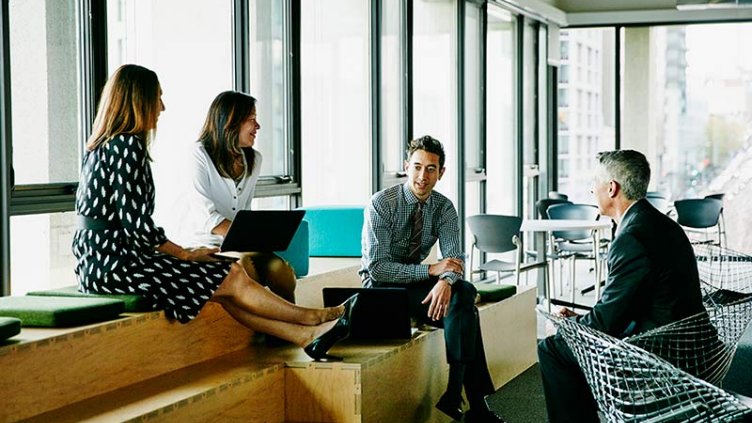 Colleagues meeting and collaborating in an informal office gathering space