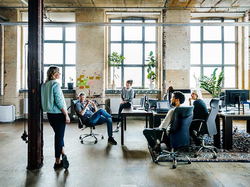 Group of colleagues communicating in a hybrid workspace