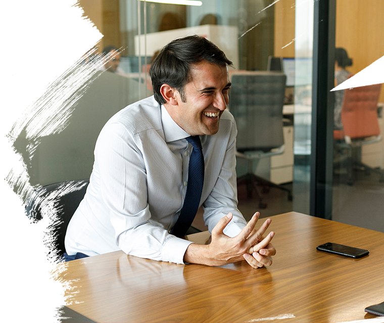 An employee sitting in office cabin and laughing
