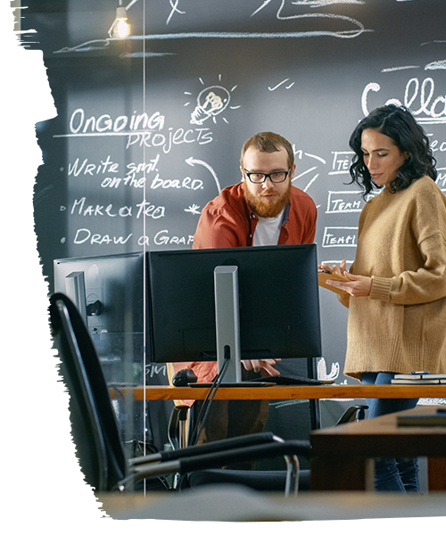 2 Office space designers discussing location strategy(Computer in front of them and blackboard in background)