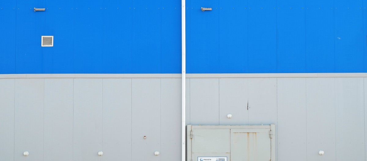 blue ad white wall ouside industrial building 