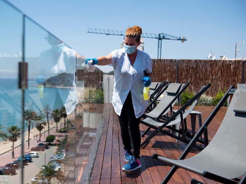 Lady cleaning the glasses on terrace